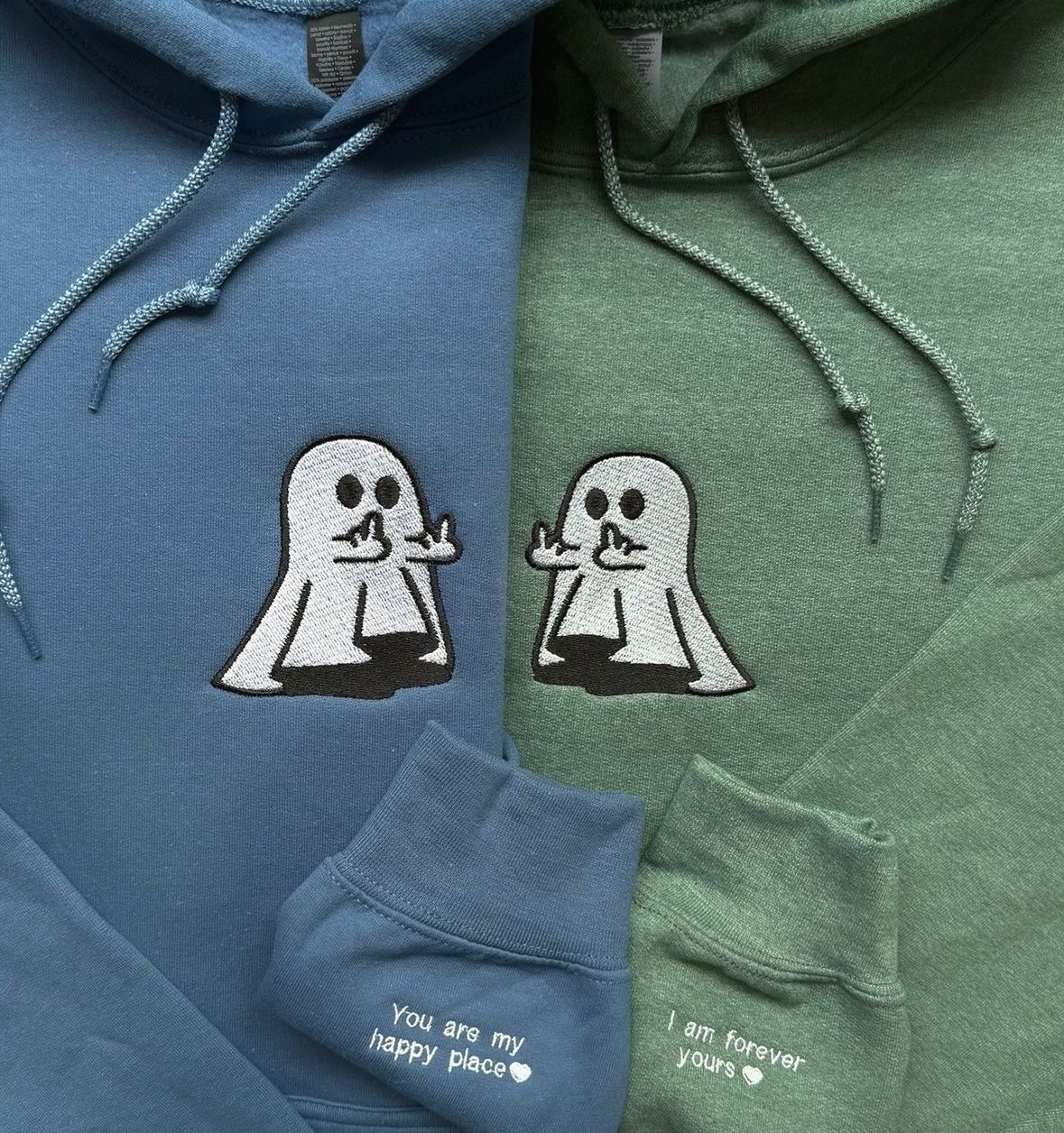 Matching couple hoodies in blue and green with embroidered ghost design and “You Are My Happy Place” / “I Am Forever Yours” text on the sleeves.