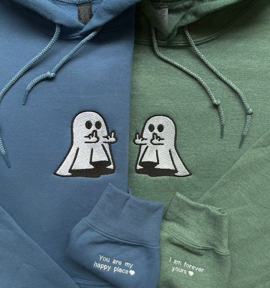 Matching couple hoodies in blue and green with embroidered ghost design and “You Are My Happy Place” / “I Am Forever Yours” text on the sleeves.